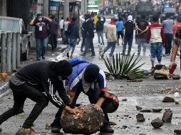 Tras la declaración del tribunal electoral, opositores se lanzaron a las calles a protestar con barricadas de piedras, hogueras de neumáticos y palos. AFP / ARCHIVO