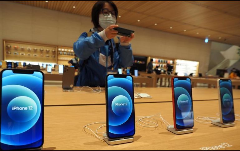 Una mujer le toma una fotografía a un iPhone 12 en una tienda de Taipei. EFE/D. Chang