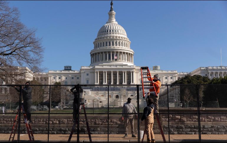 Trabajadores instalan una reja en el frente oeste del Capitolio en Washington, DC, un día después del asalto al recinto legislativo. EFE/EPA/M. Reynolds