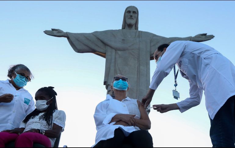 Una enfermera y una anciana de 80 años reciben hoy la vacuna en un acto simbólico a los pies del Cristo Redentor en Río de Janeiro, Brasil. EFE/F. Motta