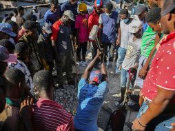 Civiles luchan para sacar a personas de los escombros.  AP/J. Odelyn