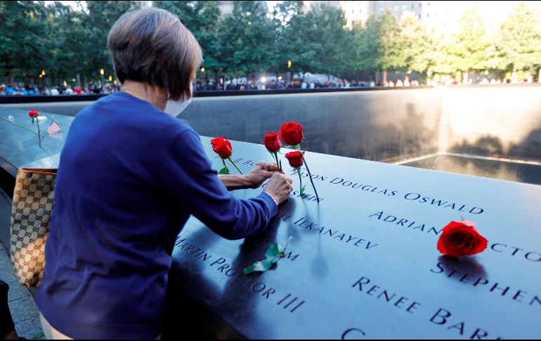 Una mujer coloca flores en el memorial de las víctimas del 11 de Septiembre en Nueva York a 20 años de ataque terrorista. EFE / M. Segar