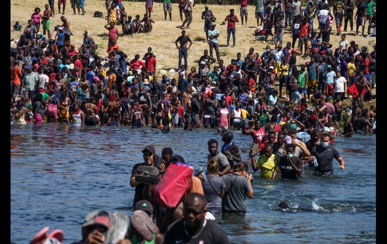 Migrantes haitianos que se alojan en un campamento en Texas cruzan hoy el río Bravo cerca de Del Río hacia Ciudad Acuña, con el fin de obtener alimentos del lado mexicano. AFP/P. Ratje