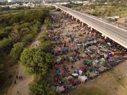 Migrantes, la mayoría de Haití, se ven hoy en el campamento improvisado junto al puente internacional en Del Río, Texas, cerca del río Bravo. AP/J. Cortez