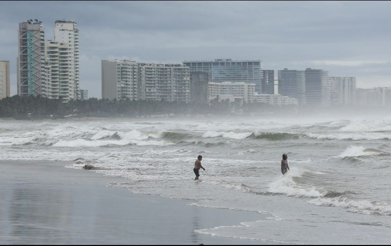 Personas se bañan en una playa mientras el huracán 