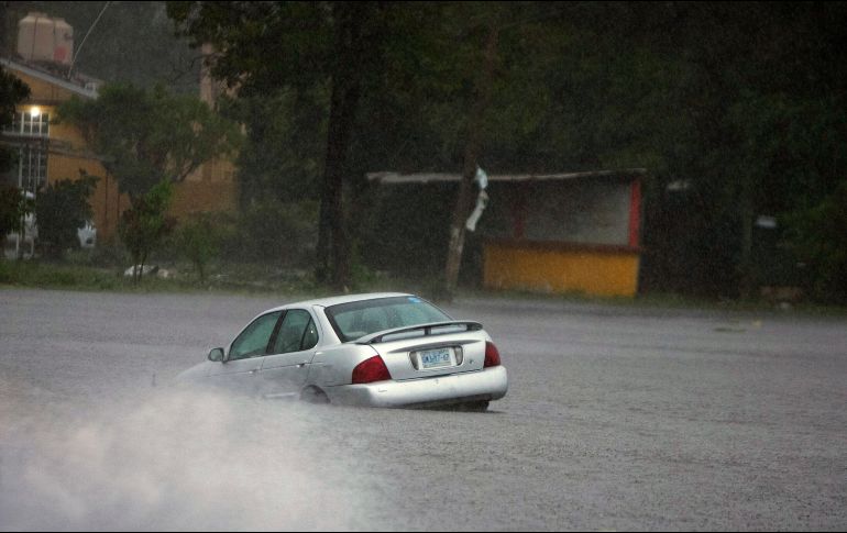 Un automóvil atascado en una calle inundada debido al huracán 