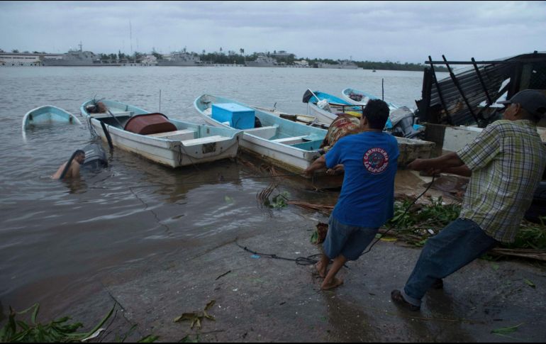 Un grupo de pescadores pone a salvo su embarcación, en el puerto de Lázaro Cárdenas, Michoacán. AP / A. Solís