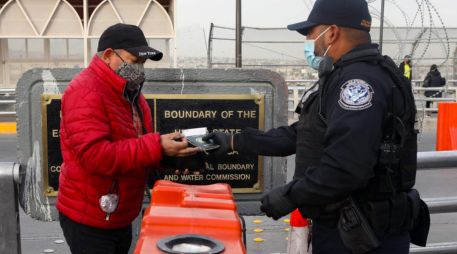 Un agente estadounidense de Protección Fronteriza y Aduanas solicita el certificado de vacunación anti COVID-19 a un hombre que quieren cruzar de Ciudad Juárez a El Paso. AFP/H. Martínez