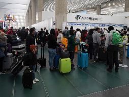 Pasajeros hacen hoy fila en un mostrador de Aeroméxico en el Aeropuerto Internacional de la Ciudad de México. La aerolínea ha registrado varios vuelos cancelados. AP/F. Llano