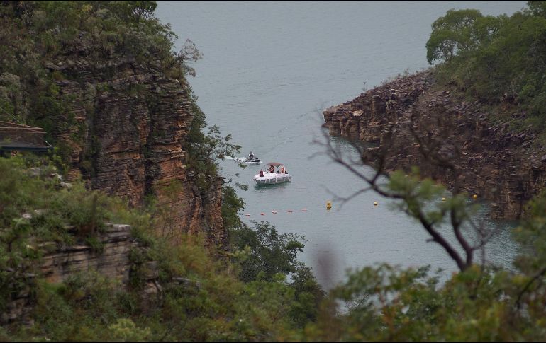 Un bote se ve hoy en el lago de Furnas, donde el sábado se desprendió la roca sobre botes turísticos. Labores de búsqueda continuaban en la zona. AP/I. do Vale