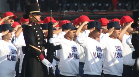 Varios jóvenes del Servicio Militar Nacional, vestidos con playera blanca, pantalón de mezclilla y gorra en color rojo, comenzaron a sentirse mal y abandonaron la formación para ser atendidos. SUN