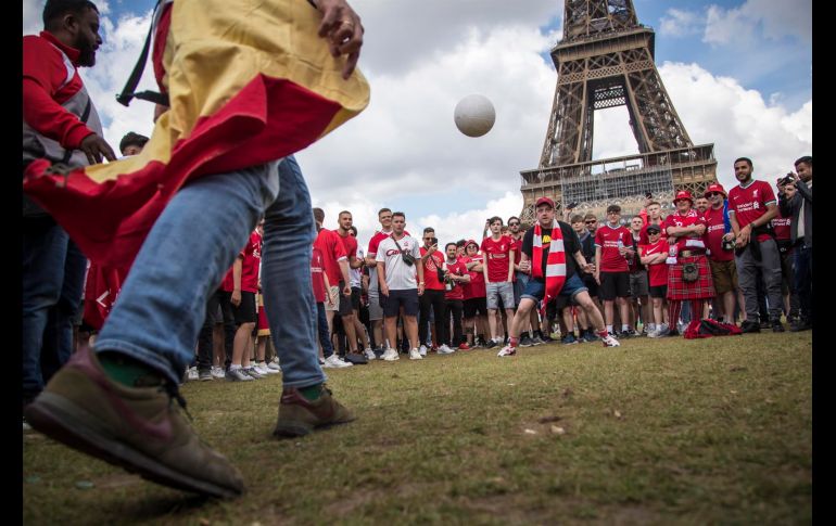 Fans del Liverpool y del Real Madrid juegan con un balón mientras se reúnen cerca de la Torre Eiffel. EFE / C. P. Tesson