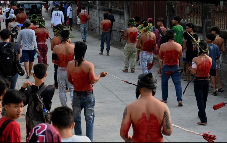 Decenas de hombres desfilaron con la cara cubierta mientras se azotaban con ramas de bambú. AFP / J. Sta Rosa