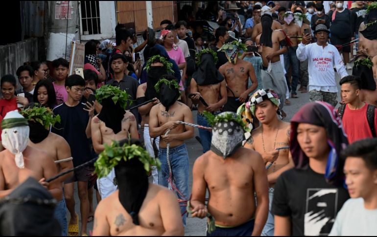 Decenas de hombres desfilaron con la cara cubierta mientras se azotaban con ramas de bambú. AFP / J. Sta Rosa