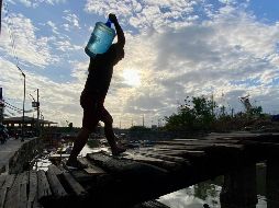 Un hombre carga un recipiente con agua en una aldea de Filipinas. La ONU estima que alrededor de 2 mil 200 millones de personas no tienen acceso a agua potable segura. EFE/F. Malasig